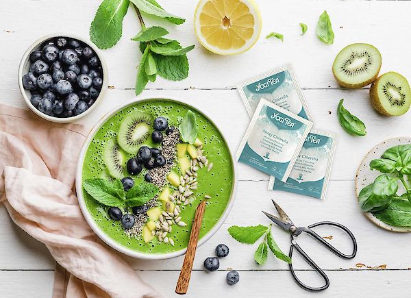 Colourful green smoothie bowl with spinach and blueberries