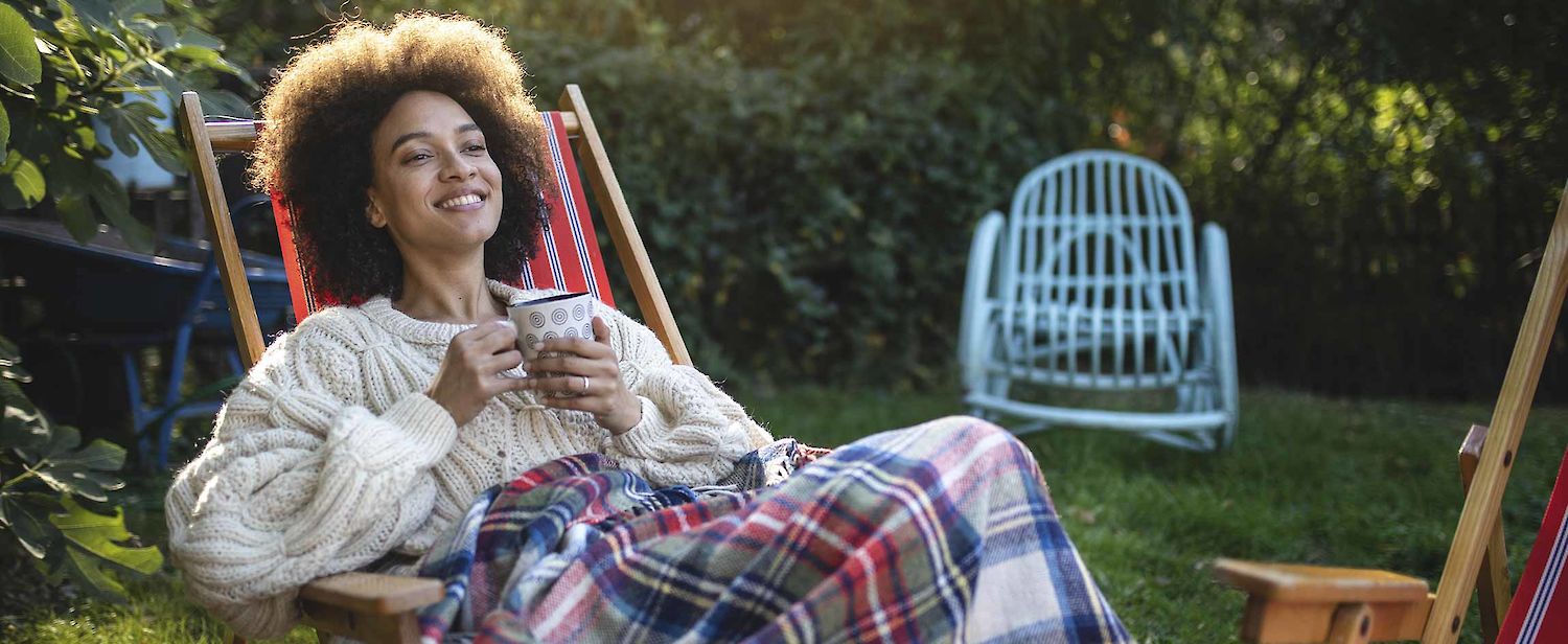 Frau im Garten mit Teetasse